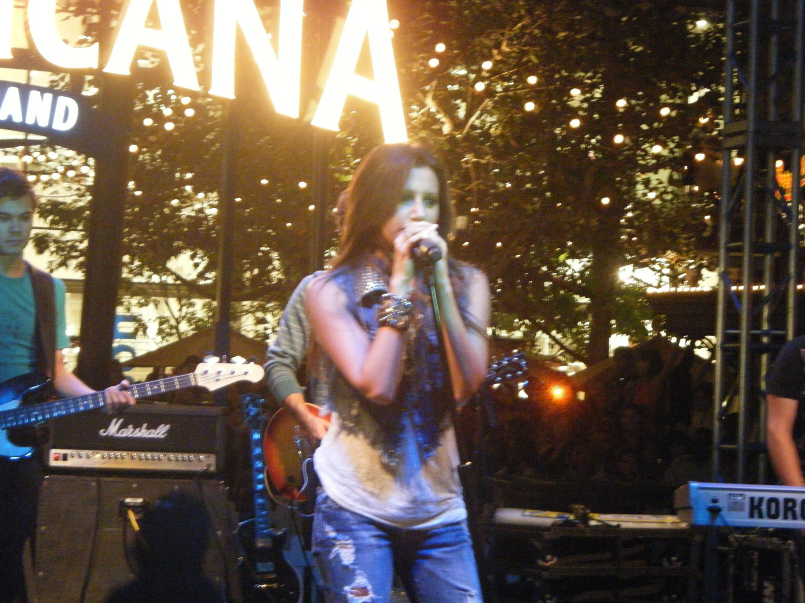 Ashley Tisdale singing on stage at The Americana at Brand at night, August 2009